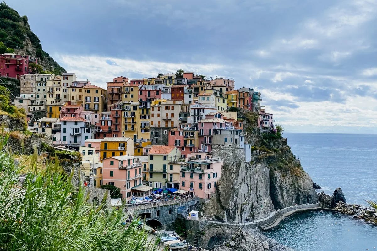 Multi-colored buildings of Cinque Terre on a hillside overlooking the ocean.