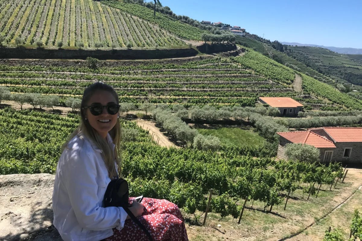 A picture of Tori in a white shirt sitting near the Douro Valley winery.