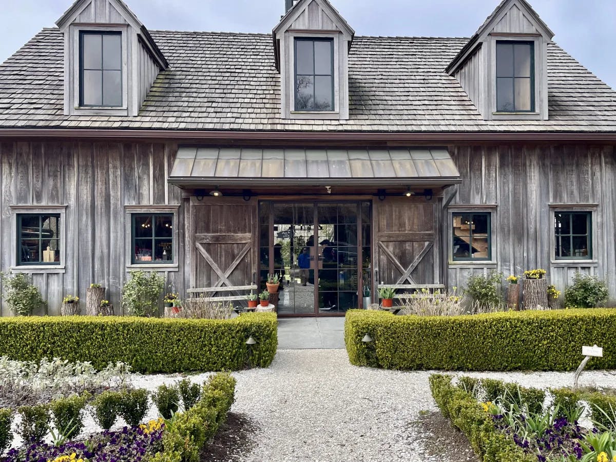 Beach Plum Farm, a weathered gray building with landscaped hedges out front