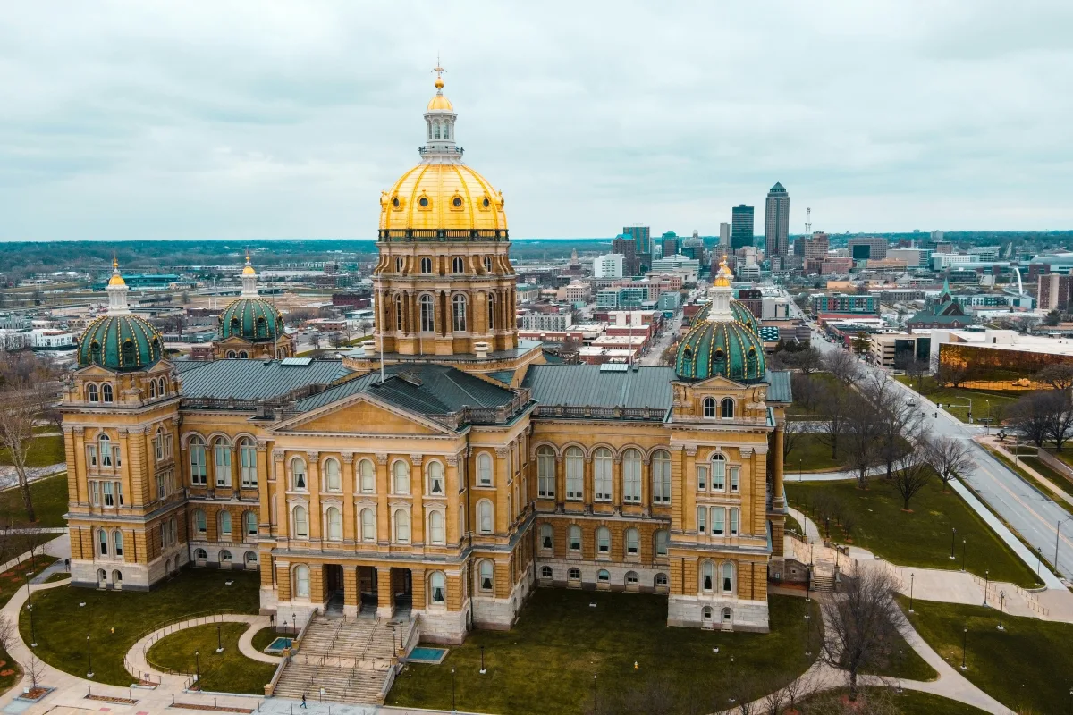 an aerial view of the capitol building with a golden dome at its center. 