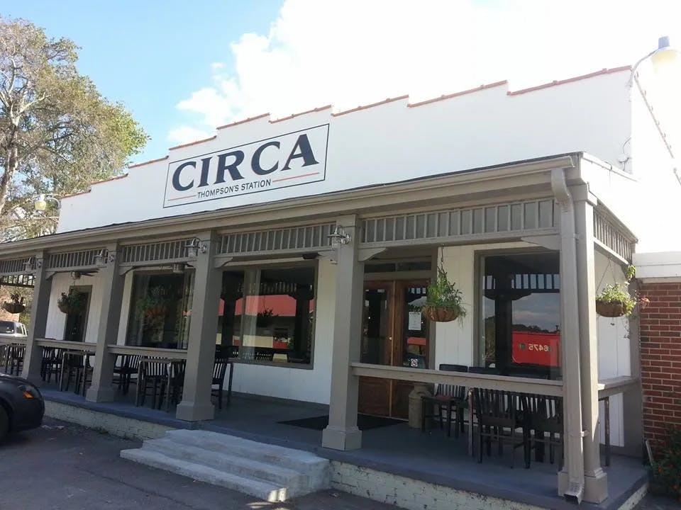 A white restaurant with a porch and a "Circa" sign.