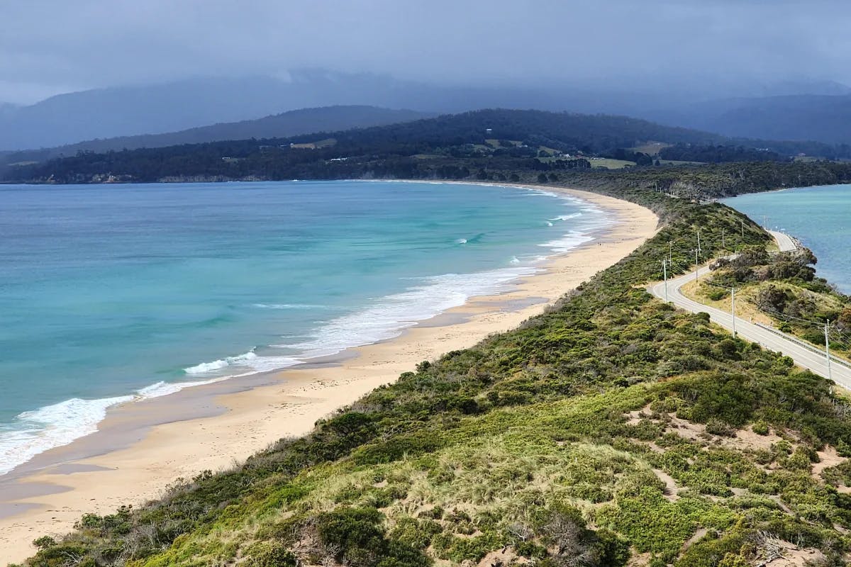 Bruny Island, with a long narrow strip of tree-and sand-covered land and water on either side.