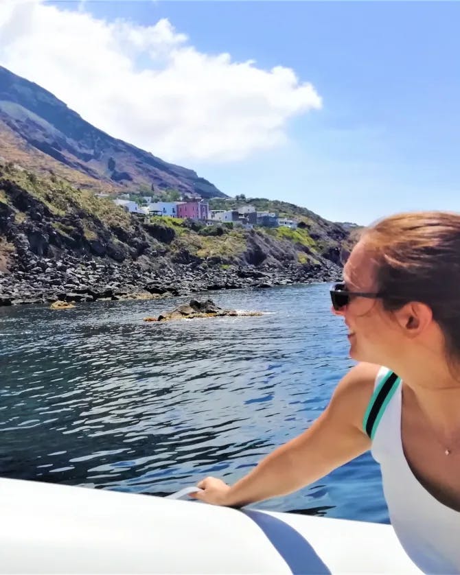 Picture of Antonella on a boat with the ocean and a mountain scape in the background. 