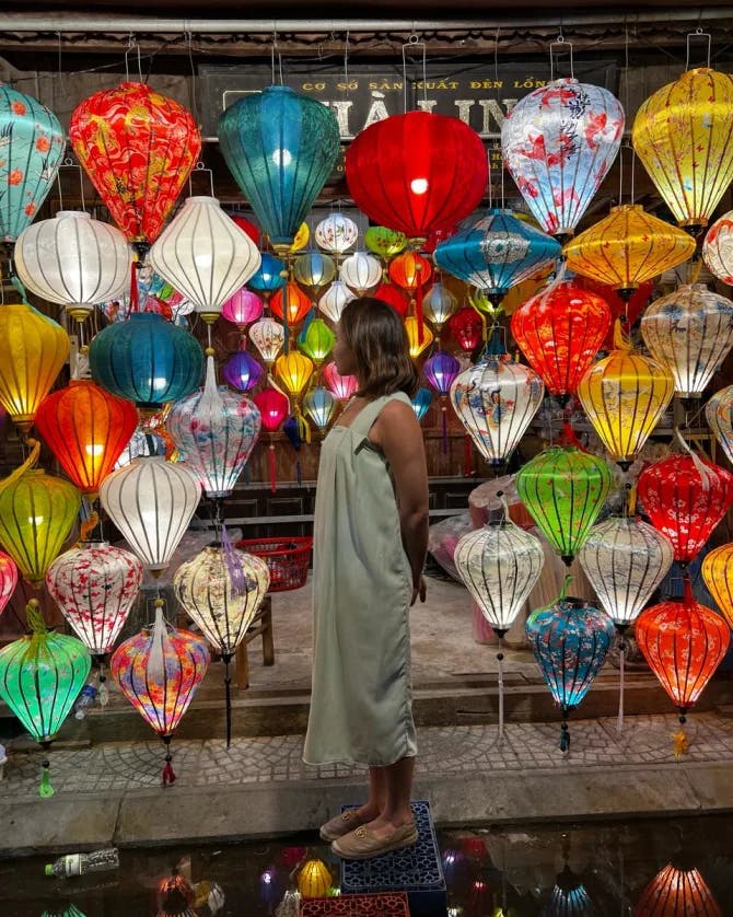 Travel advisor Sharon looking at brightly colored hanging lanterns 