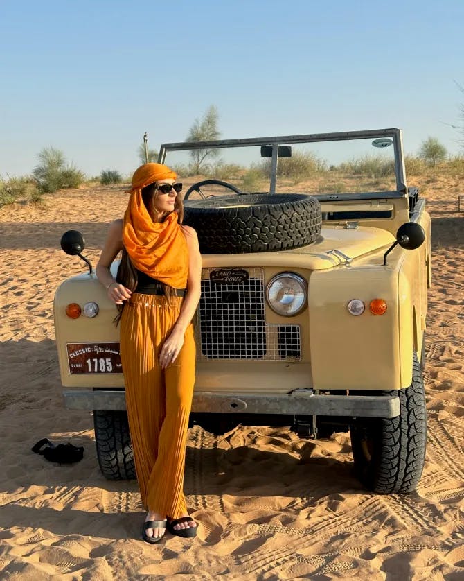 Travel Advisor Lauren Ruehl outside in front of a car in the desert.