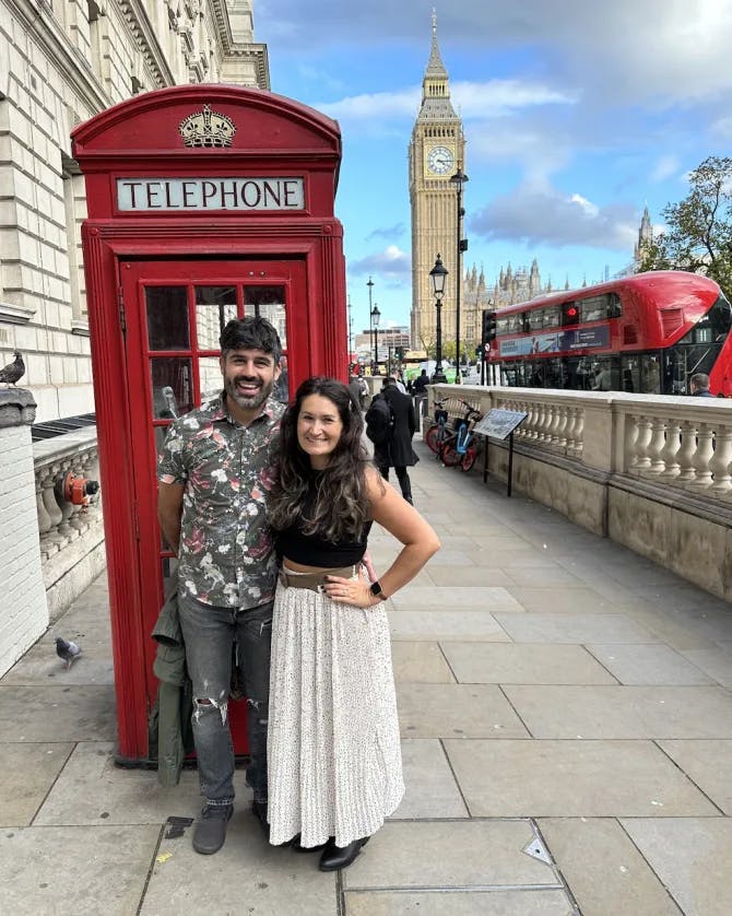 Couple posing in front of telephone booth