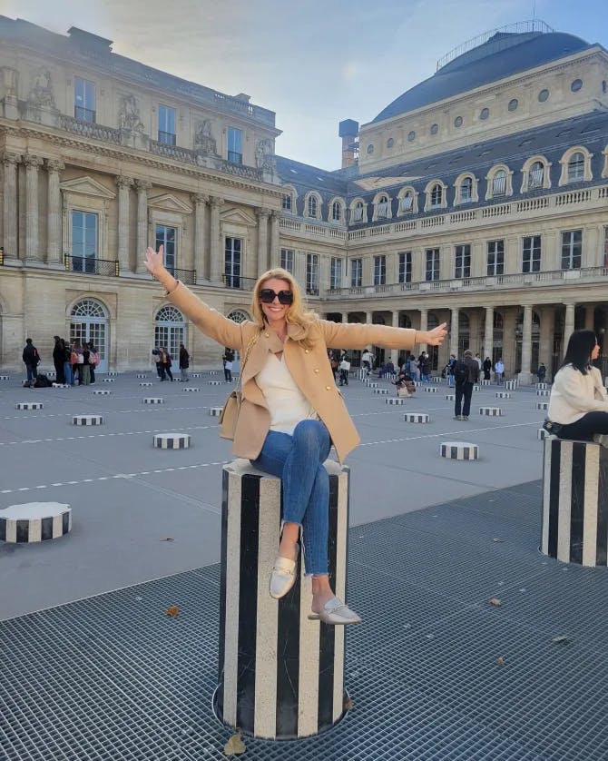 Travel advisor Megan Valente posing in front of the Palais-Royal Garden