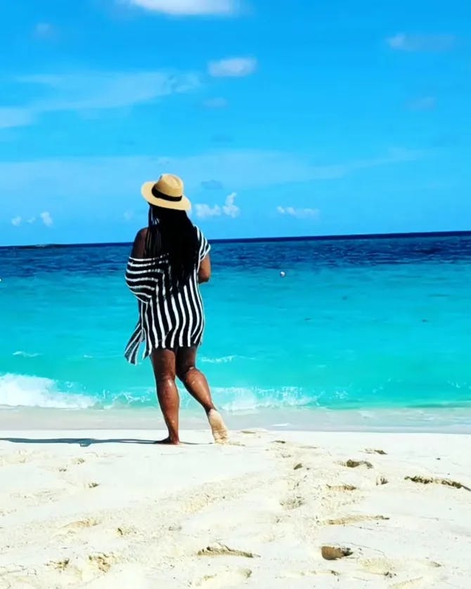 Travel advisor Michele  in a hat on a beautiful beach