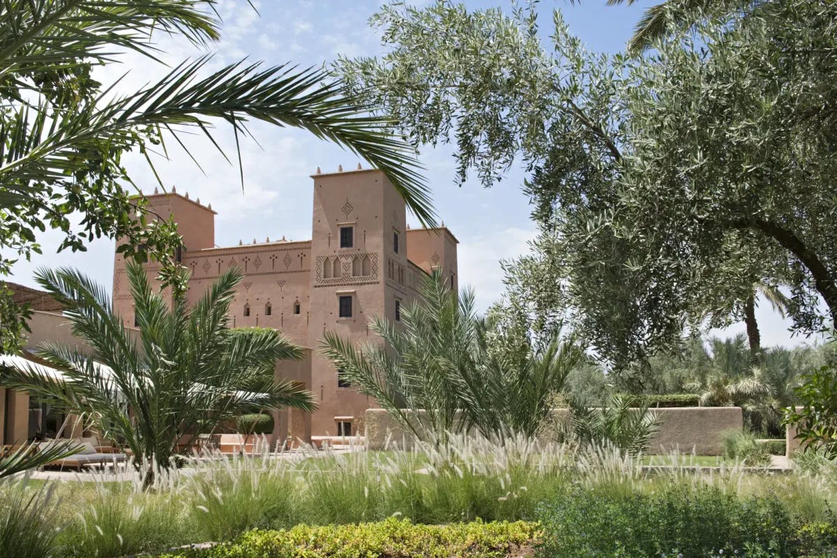 Manicured desert vegetation and trees conceal a Moroccan castle, the Dar Ahlam hotel
