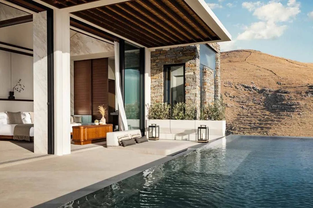 a hotel room that opens up to a patio with an infinity pool