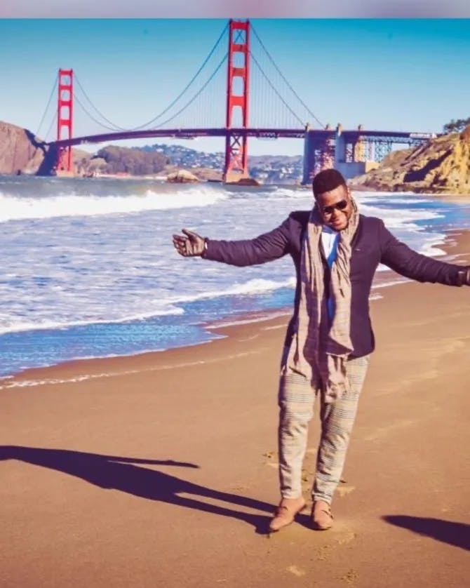 Travel advisor Samuel posing on the beach with the Golden Gate Bridge in the background