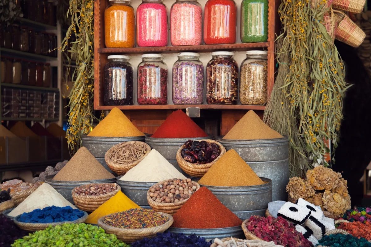 Various spices pile high on shelves and tables owned by a trader in the Marrakech Medina souks