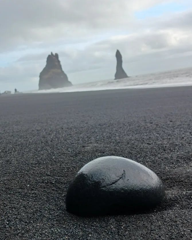 View of black sand and black round rock on Reynisfjara Beach