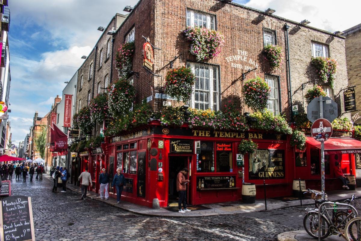 Classic Irish corner pub on cobblestone street in Dublin, Ireland on a sunny day. 