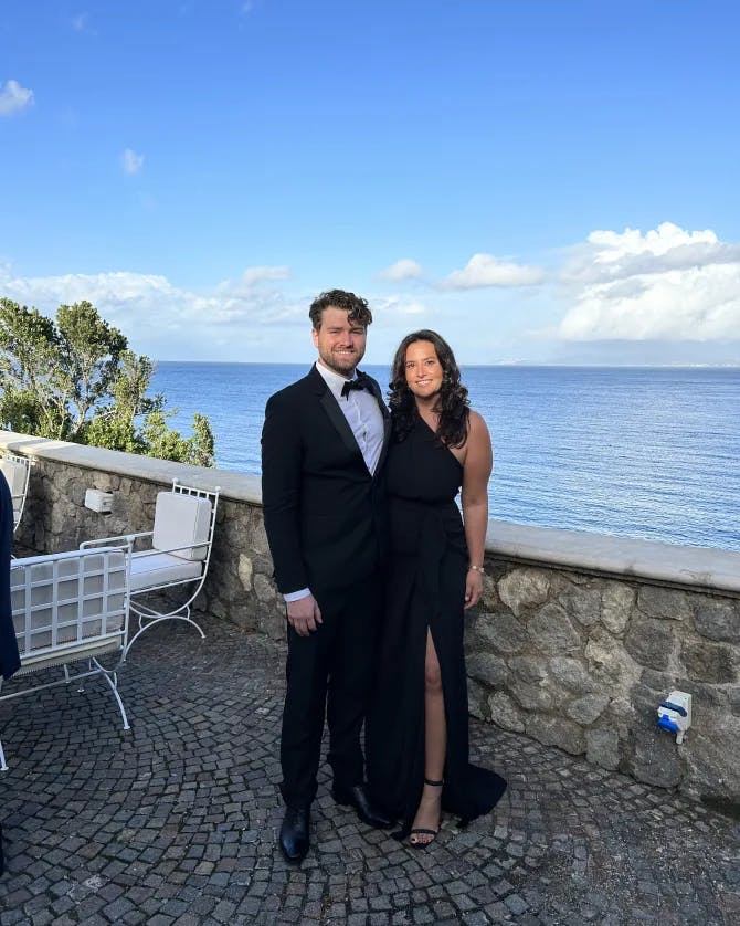 Travel advisor Rebecca King posing in an elegant black dress with companion overlooking the ocean