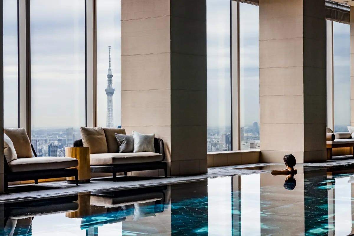 a sleek indoor swimming pool overlooking an urban landscape