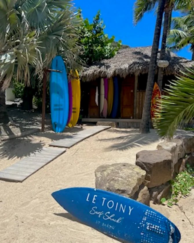 View of surfboards and a thatched hut on the beach