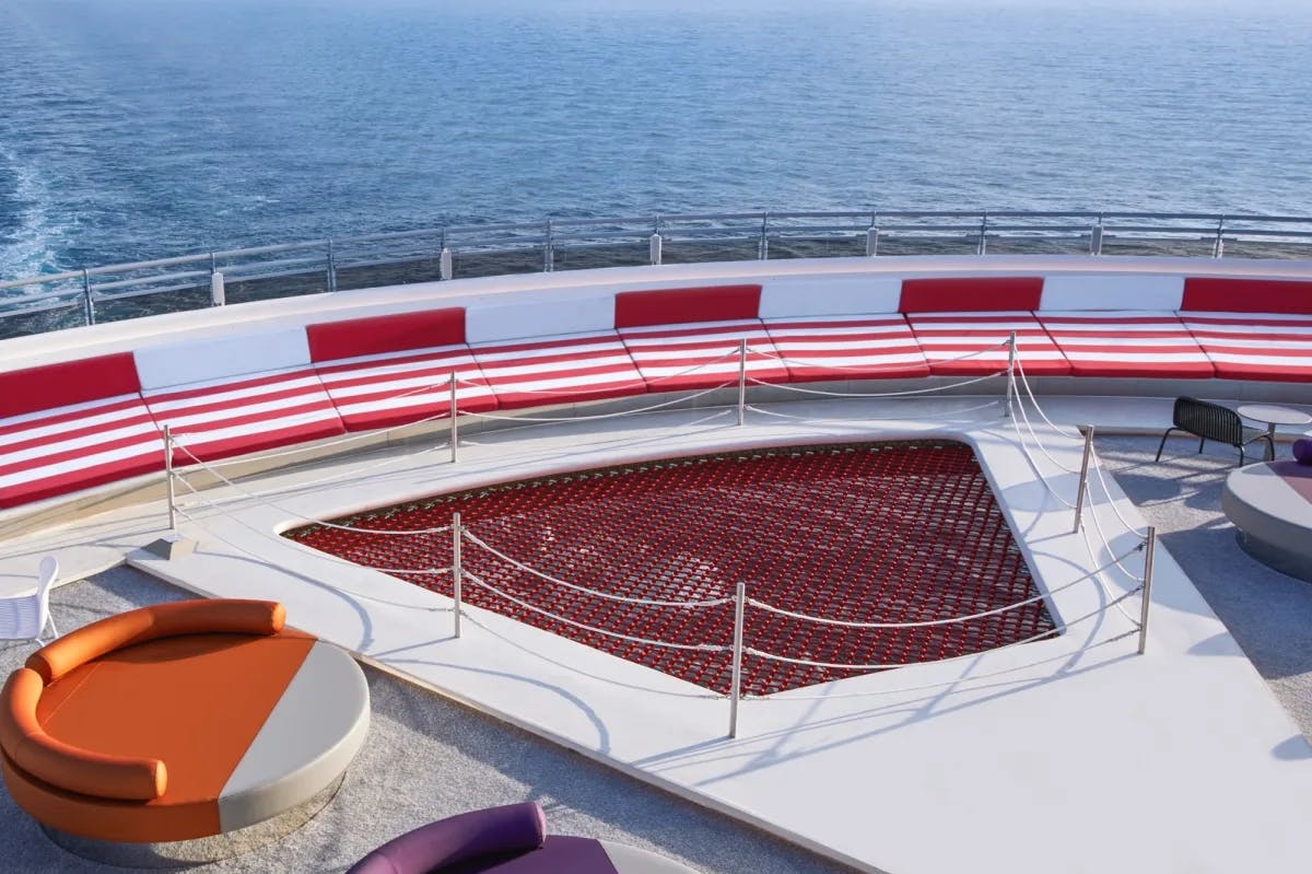 a cruise ship deck with a red  relaxation net and an orange circular lounge chair