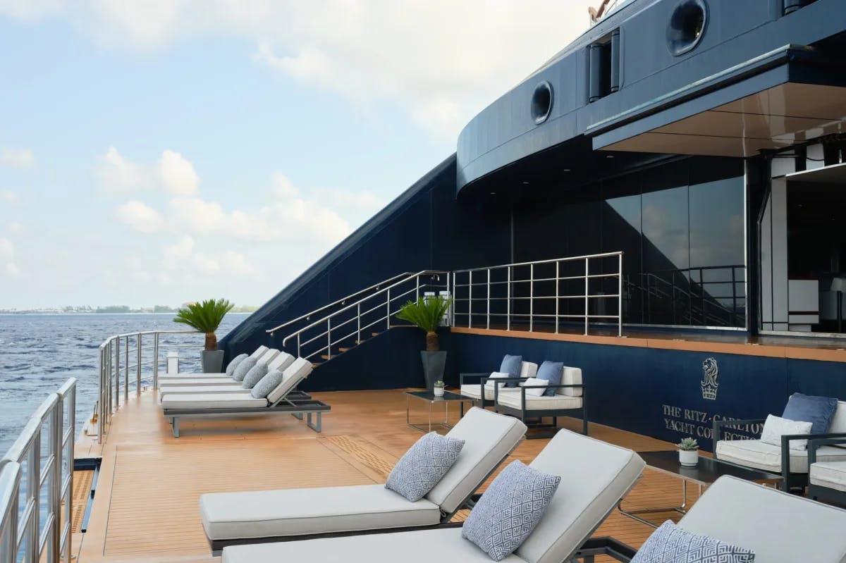 gray lounge chairs on a cruise deck overlooking the ocean