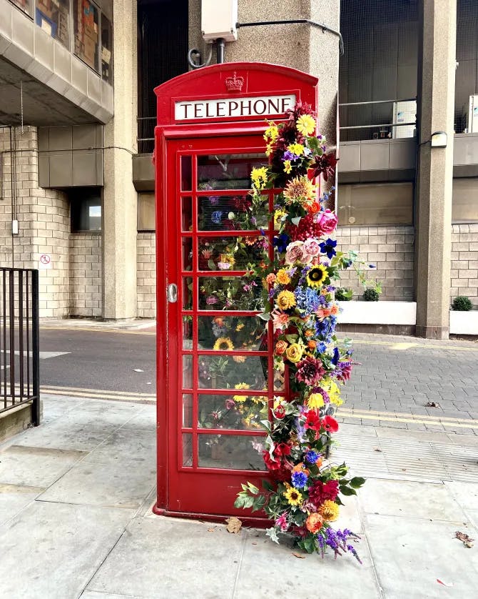 Photo of a red London phone booth decorated with flowers
