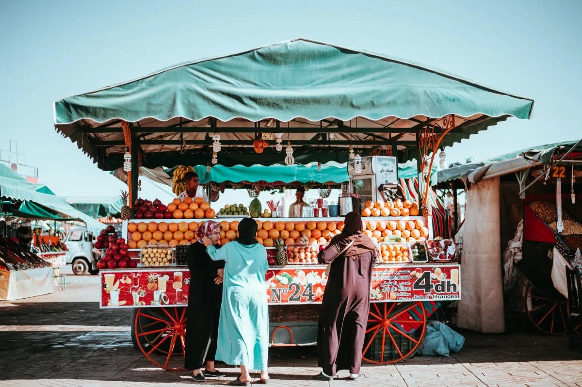Several local women order fruit from a stall somewhere in the Marrakech medina