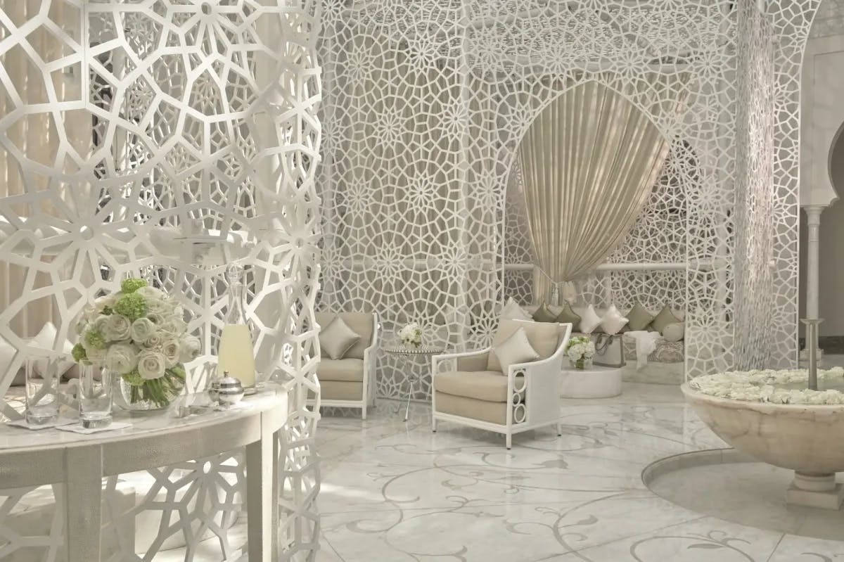Marble floors are interrupted by Moroccan-style lattice work with elegant yet simple furnishings and ornate decor