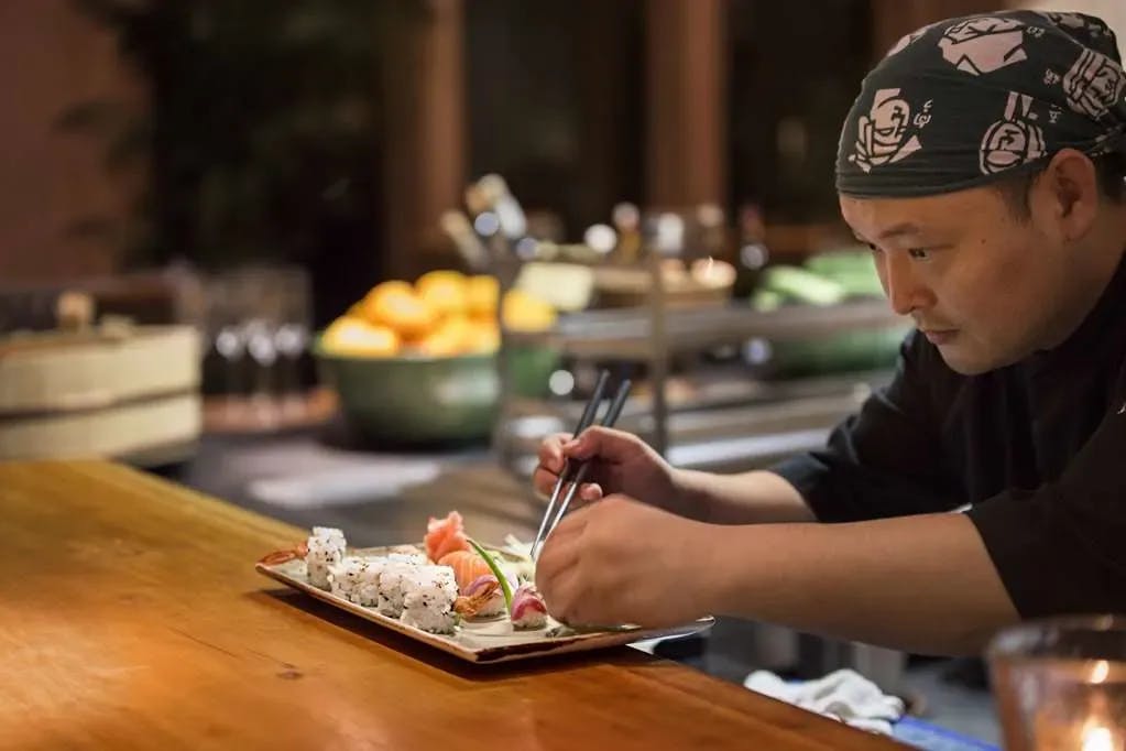 A sushi chef carefully plates sashimi at Nama, the Japanese restaurant at Amanjena in Marrakech
