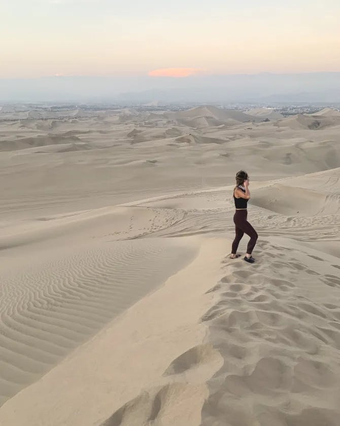Travel advisor Truc standing in the middle of the desert at sunset