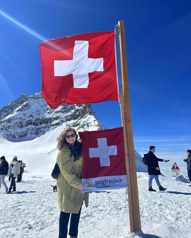 Travel advisor Haydan posing with Swiss flag in the snow