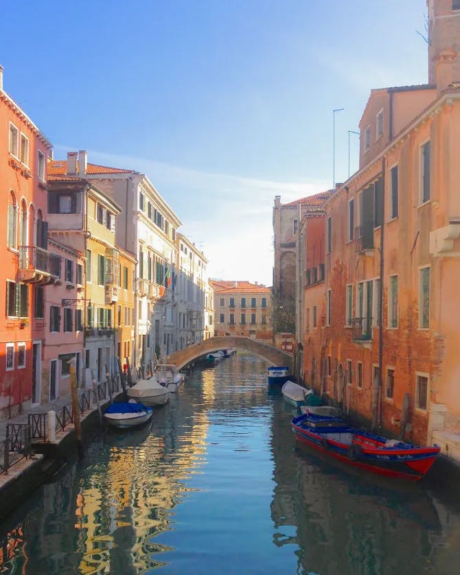 View of a canal in Venice with boats and colorful buildings either side