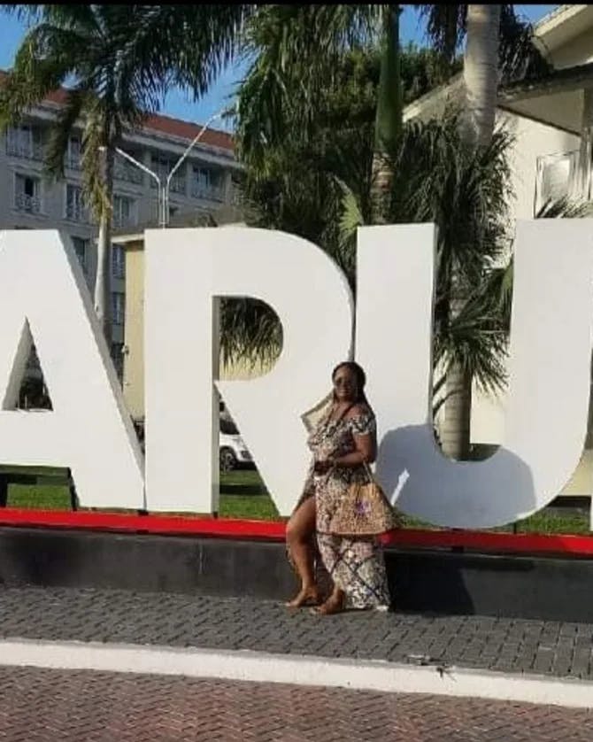 Travel advisor Michele posing with Aruba sign