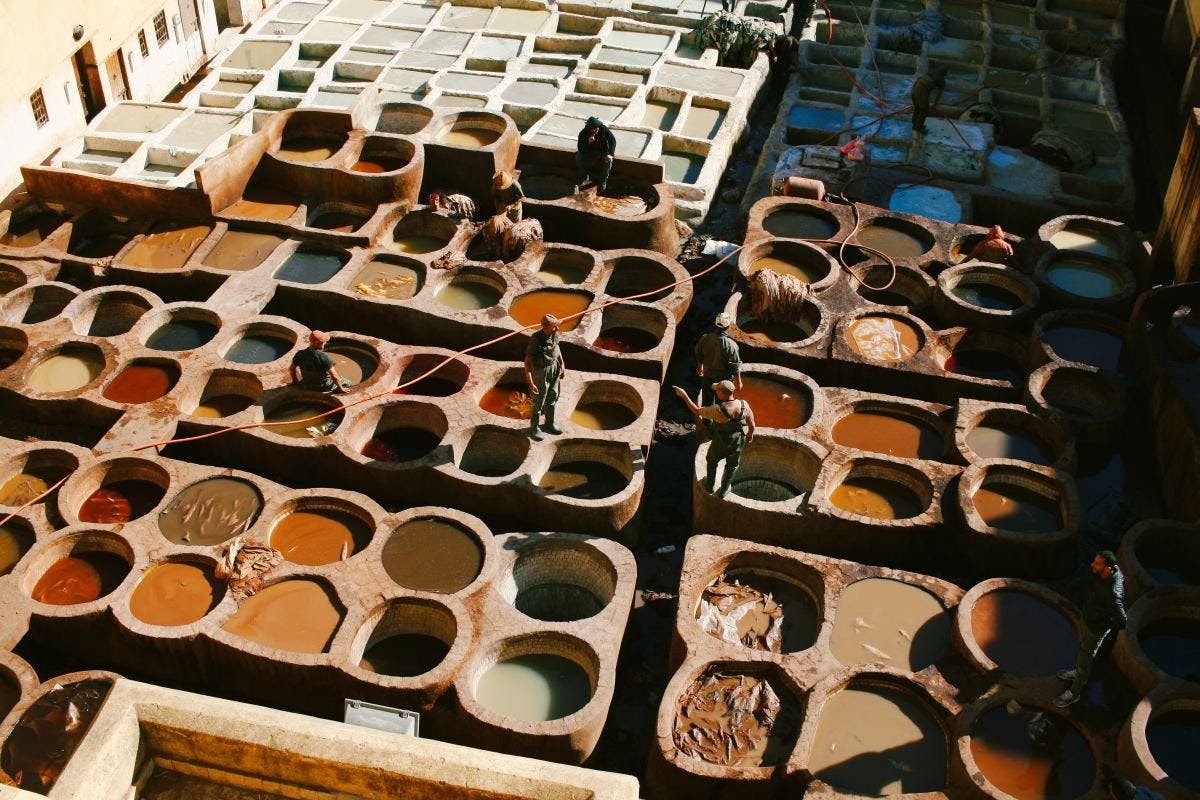 Aerial view of multiple clay pots with different liquids in a market. 