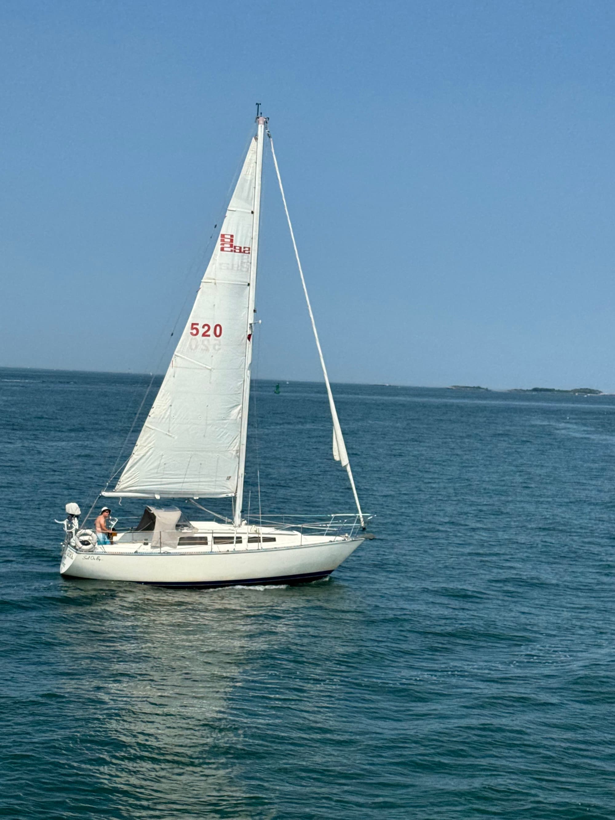 A white sailboat with the sail number 520 on open water.