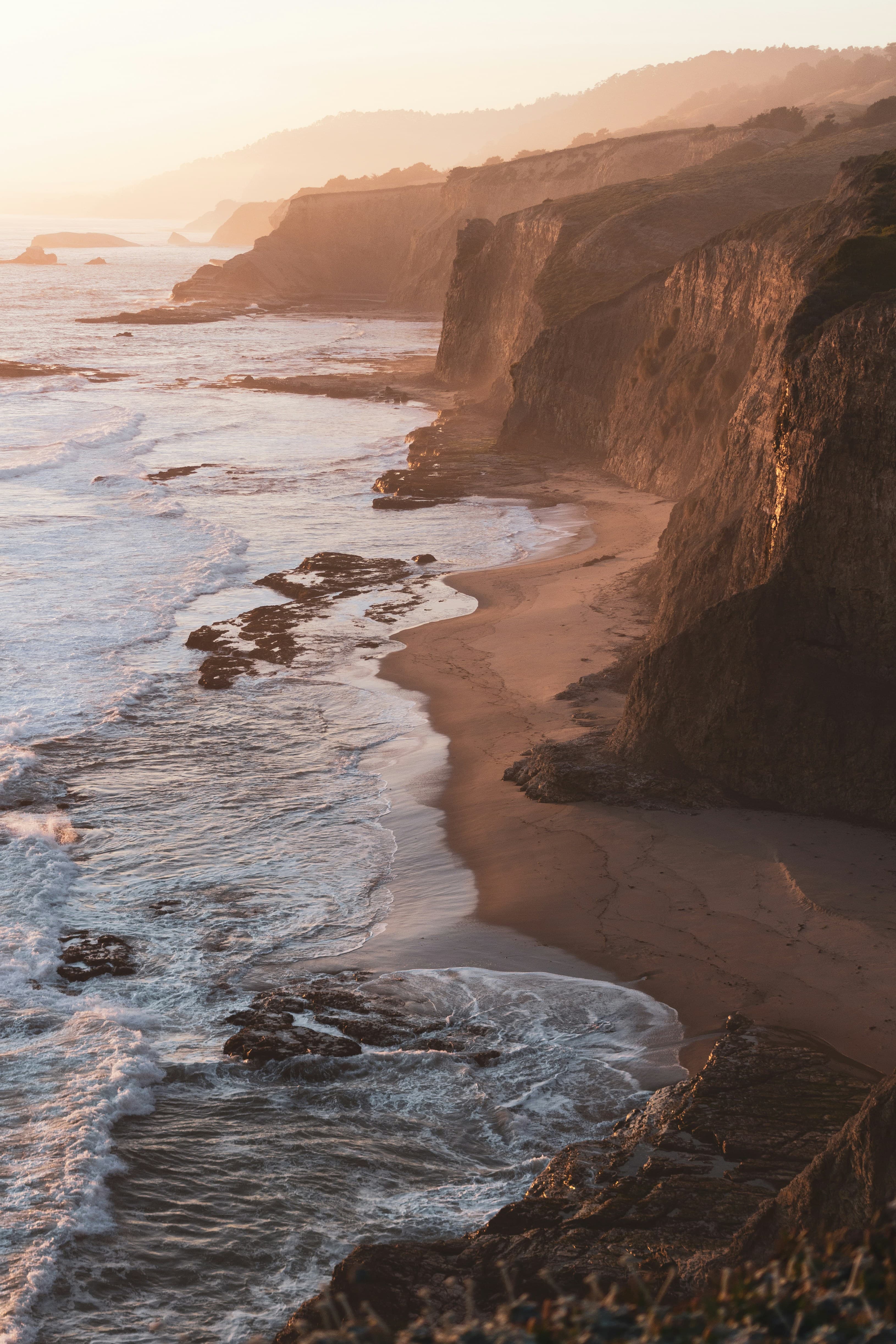 Cliffs overlooking the ocean in soft light at sunset.