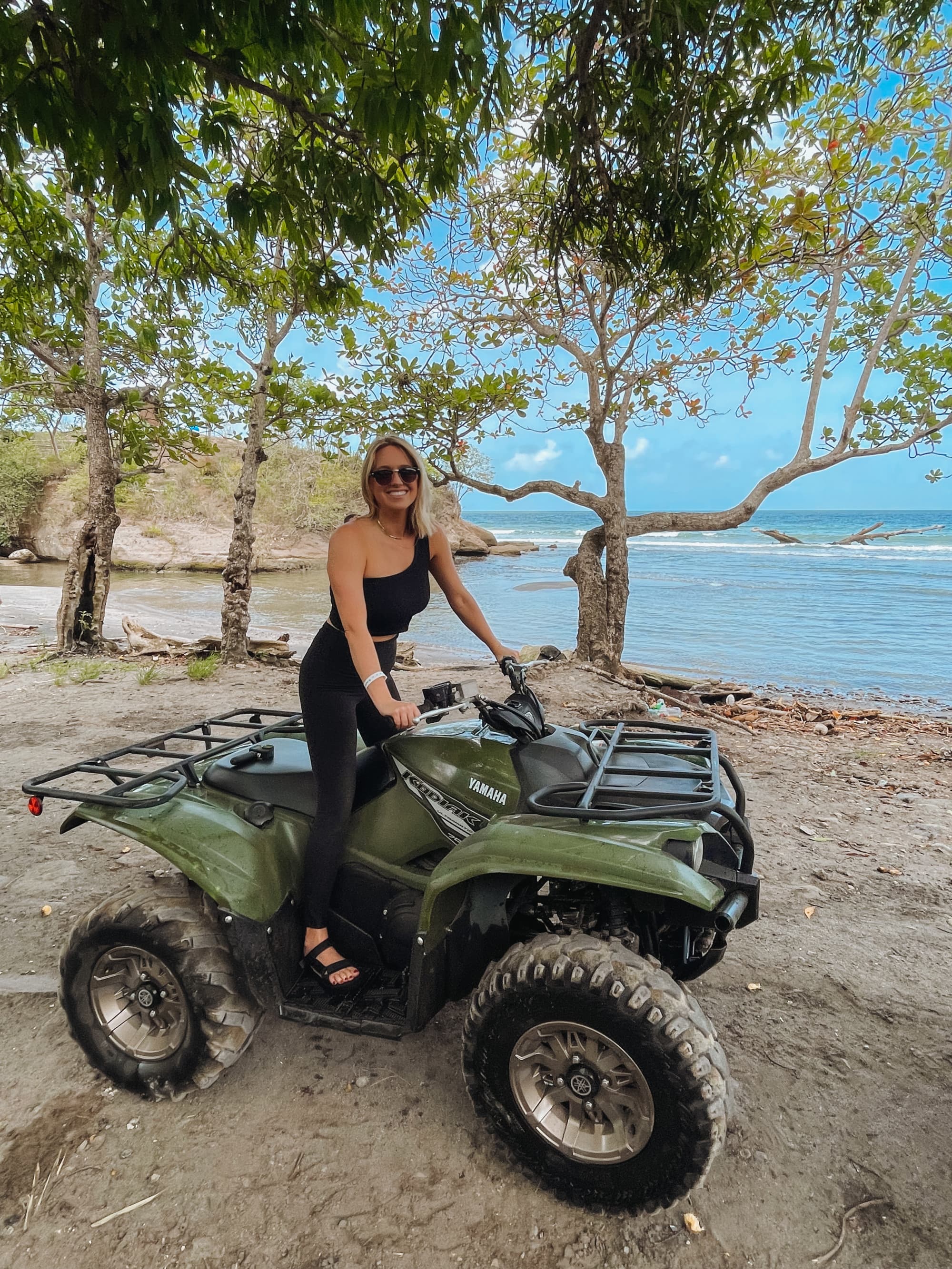 Person posing on a green four-wheeler