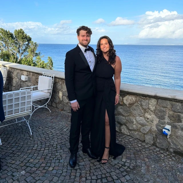 Travel advisor Rebecca King with companion posing in an elegant black dress with the ocean in view