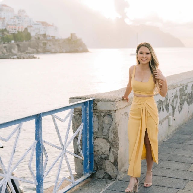 Travel advisor Truc Pham in a yellow dress posing on the waterfront