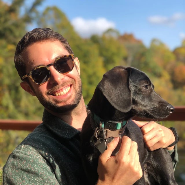 Travel Advisor Eric Schwartz is wearing sunglasses and posing with his black dog.
 