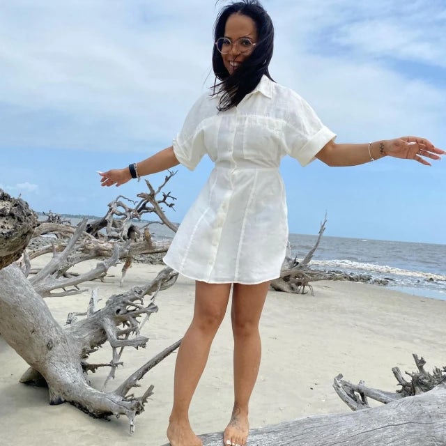 Porcherria Huff wearing a white dress while standing on the sandy beach outside. 